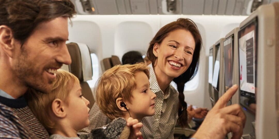 Image of mother and father sitting with their kids on an airplane