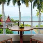 twi chairs on a balcony overlooking palm trees and ocean
