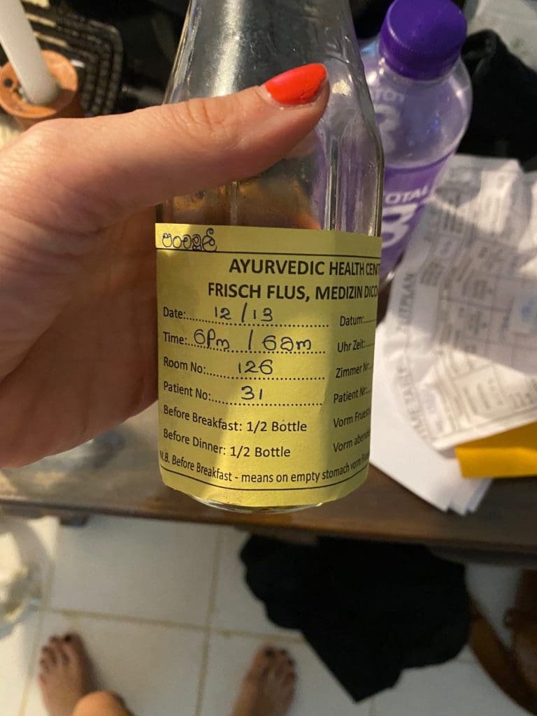 Black liquid in bottle with yellow label at Ayurvedic medicine at Barberyn Retreat.