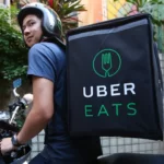 Uber Eats delivery driver on his bike with Uber Eats bag on his back. Photo: Getty