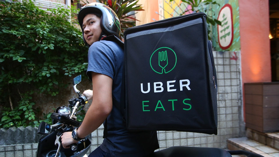 Uber Eats delivery driver on his bike with Uber Eats bag on his back. Photo: Getty