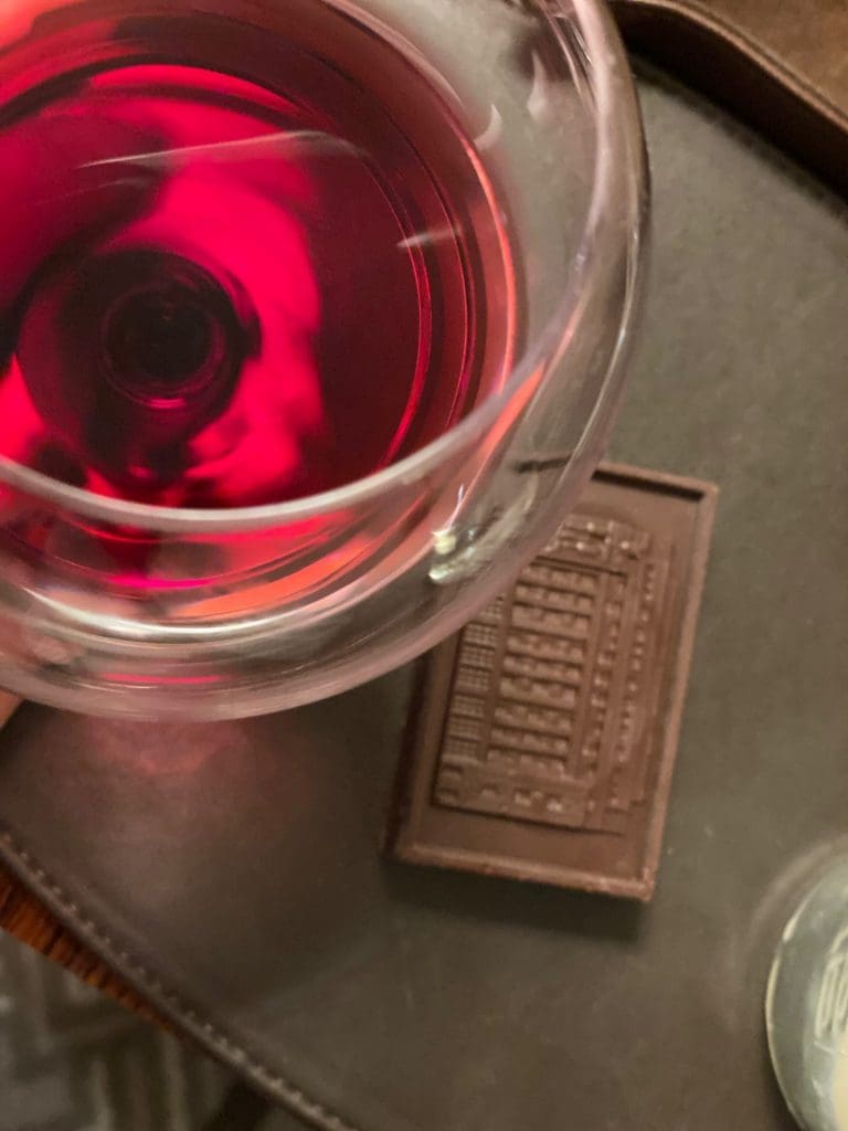 red wine in wine glass with dark square of choclate below it