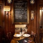 restaurant with wooden tables, wooden walls and black board with menu