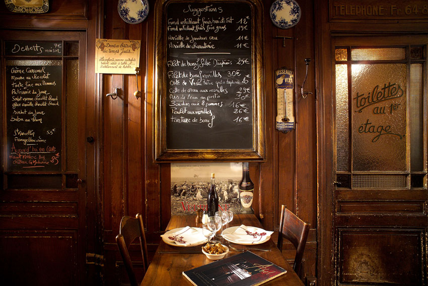 restaurant with wooden tables, wooden walls and black board with menu