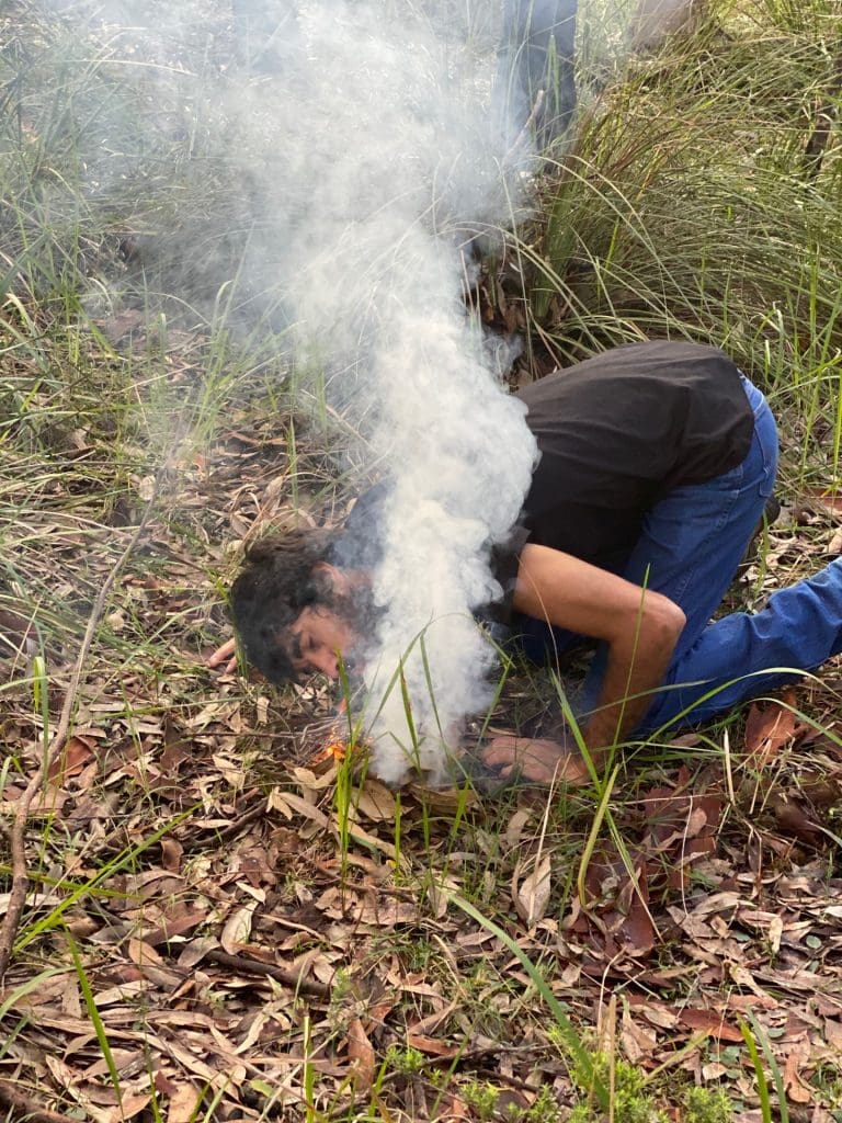 man lighting fire in the australian bush