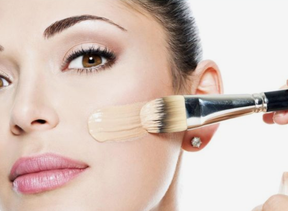 Woman brushing high coverage foundation across her cheek