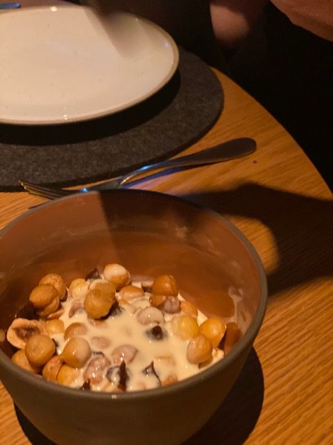 Chocolate wood roasted hazelnuts and hazelnut milk is a quirky dish of rich chocolate mousse topped with pastry style balls that look like hazelnuts as well as halved, roasted hazelnuts and hazelnut milk