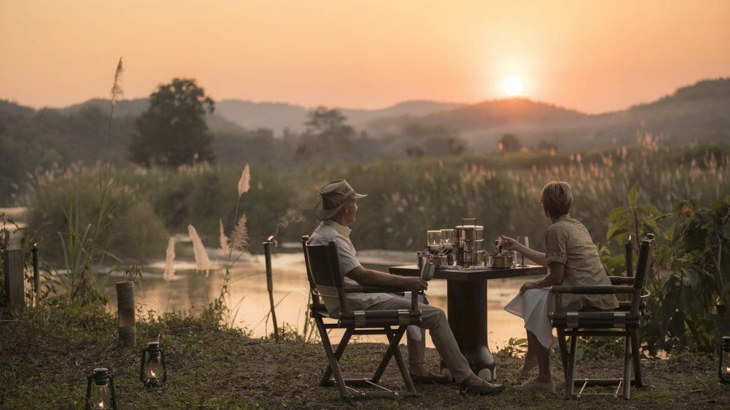 A couple on dining in the jungle at sunset 