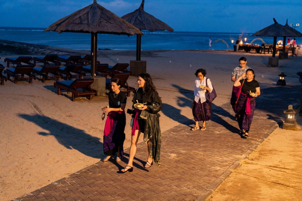 women walking on the ocean front in Bali in traditional Indonesian dress