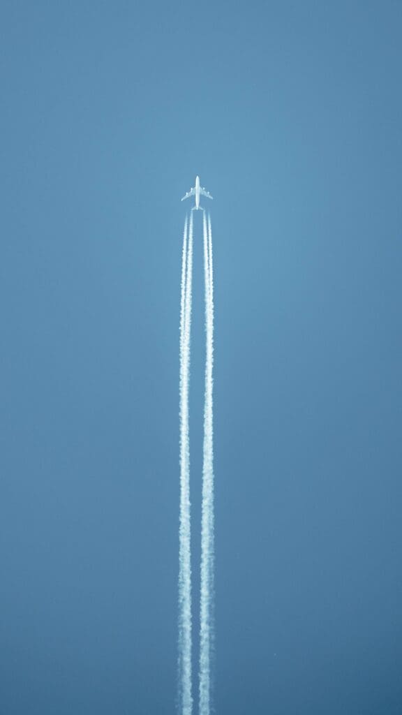 aeroplan in blue sky with white trails