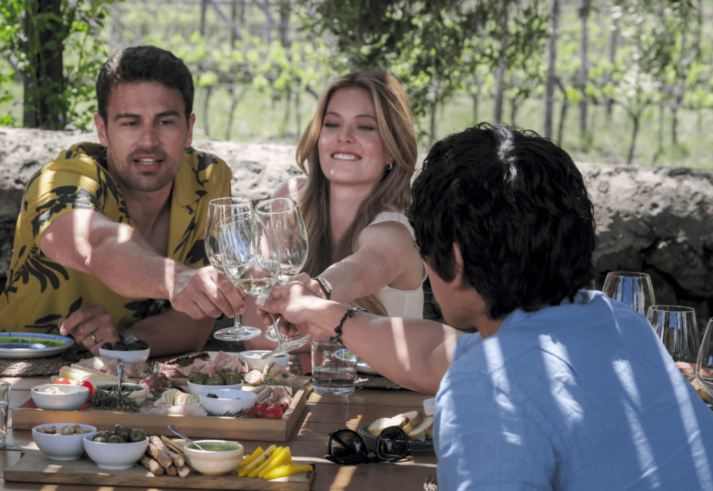 Daphne, Cameron and Ethan from the White Lotus clinking each others wine glasses.