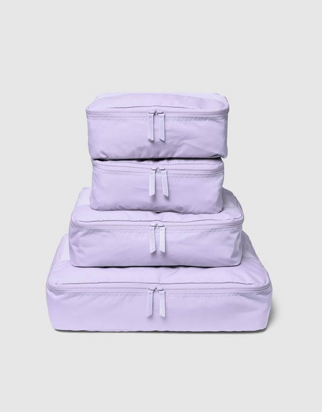 Lilac purple packing cubes stacked on each other. Top is smallest and bottom is the biggest. What to bring when travelling with just a carry-on