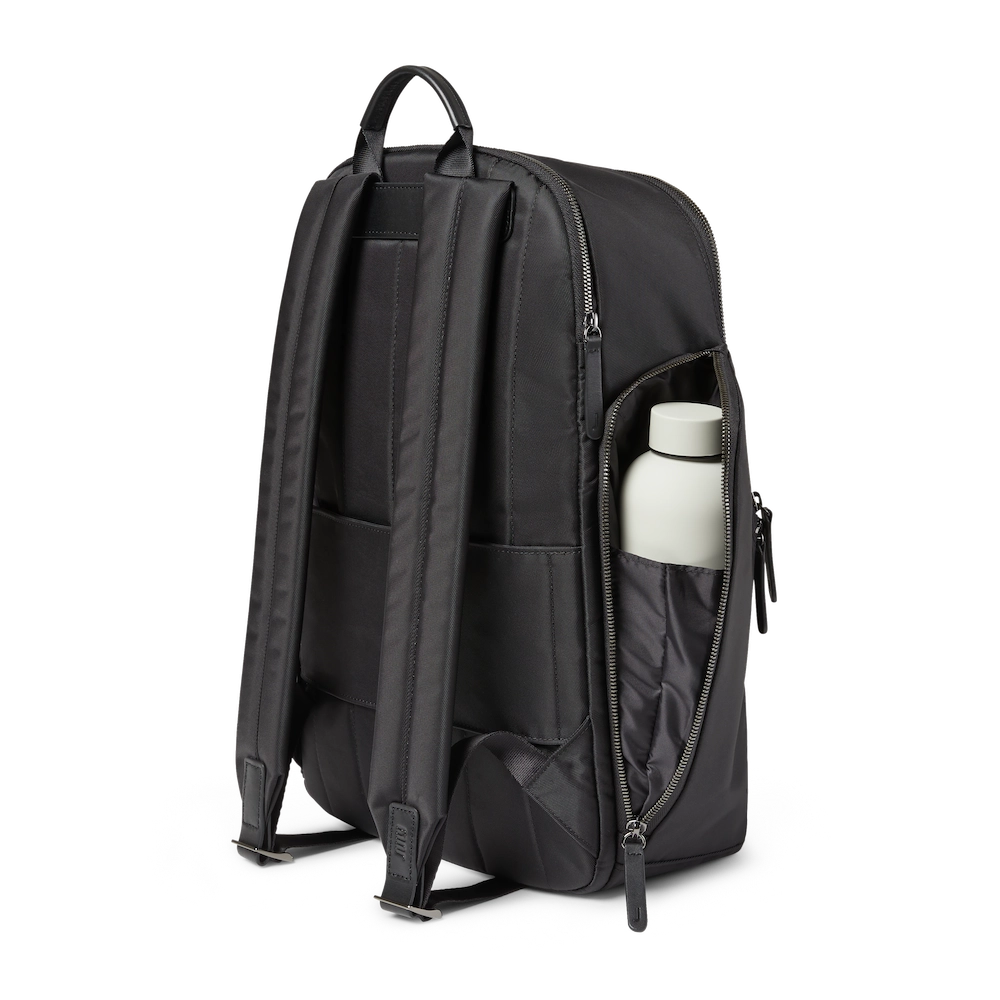 What to bring for travelling with just a carry-on. Black backpack facing backwards with a grey metal waterbottle in a pouch connected to bag. 