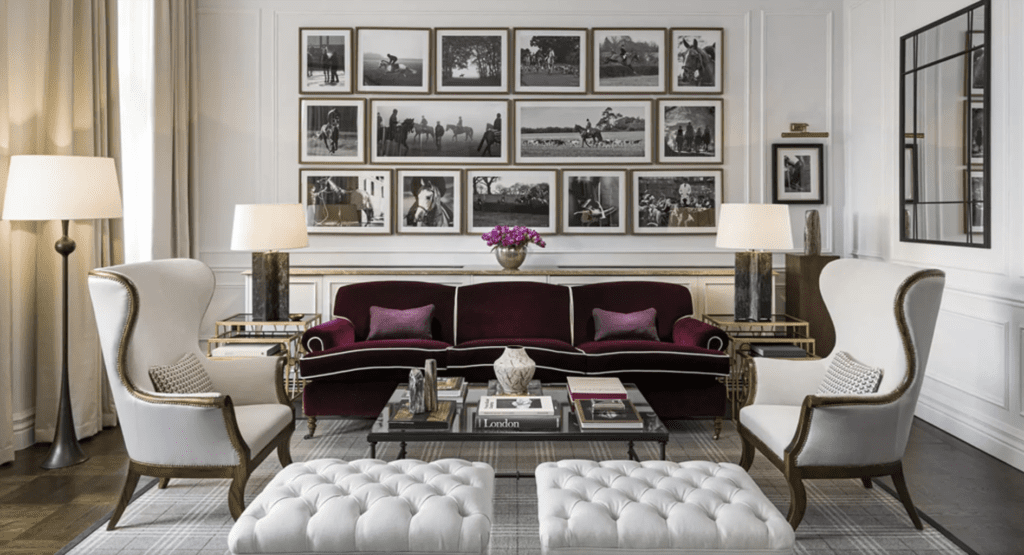 The Adria's monochromatic lounge room with a deep, jewel coloured lounge with historical british equestrian art on walls.